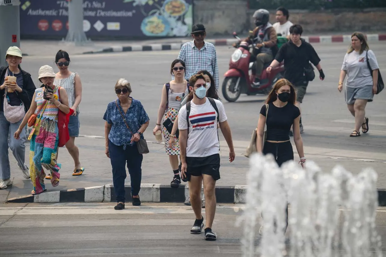 Turistas caminan con mascarillas en Tailandia.
