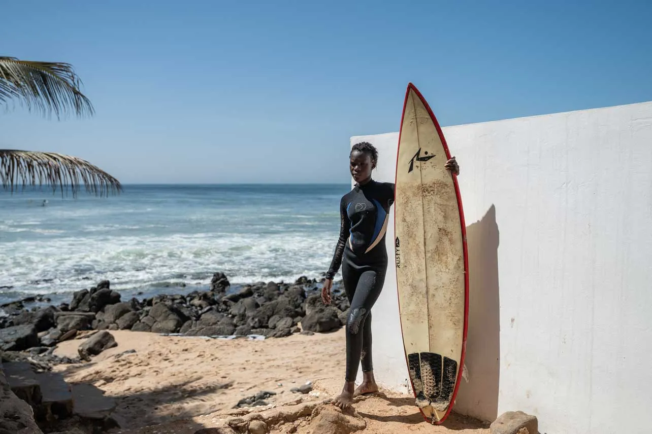 Chica con su tabla de surf en la playa.
