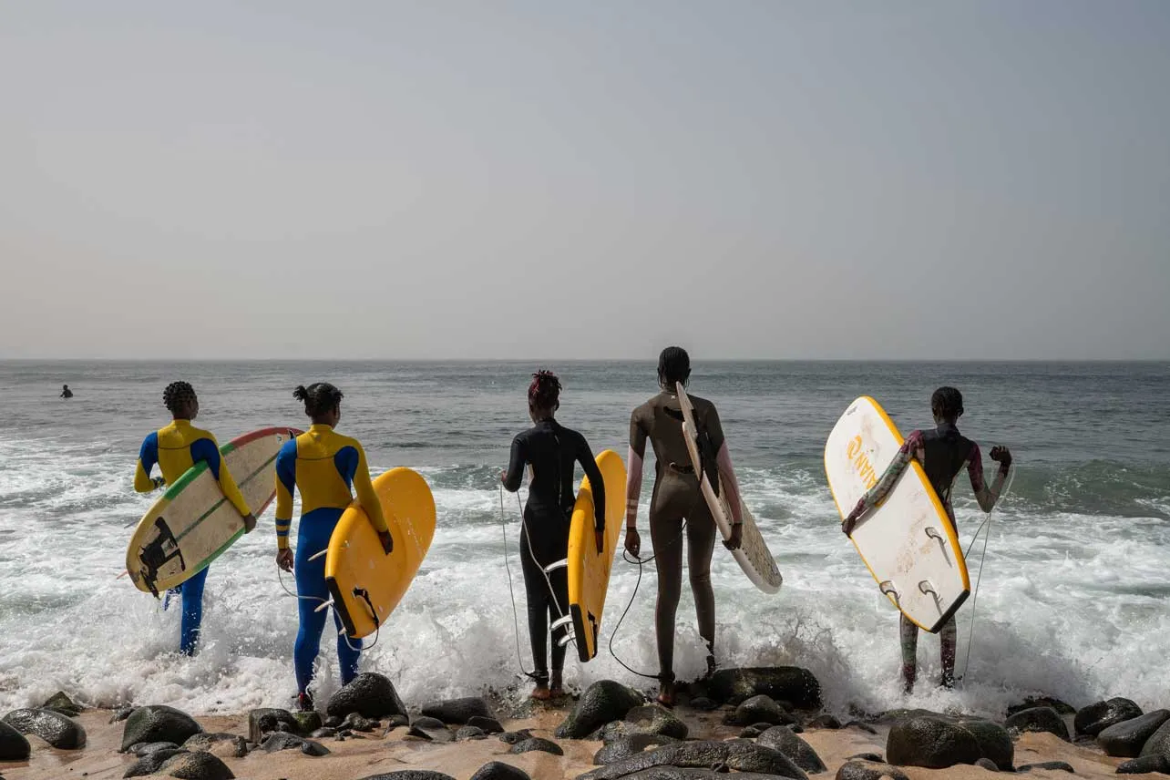 Chicas con sus tablas de surf frente al mar en Senegal.