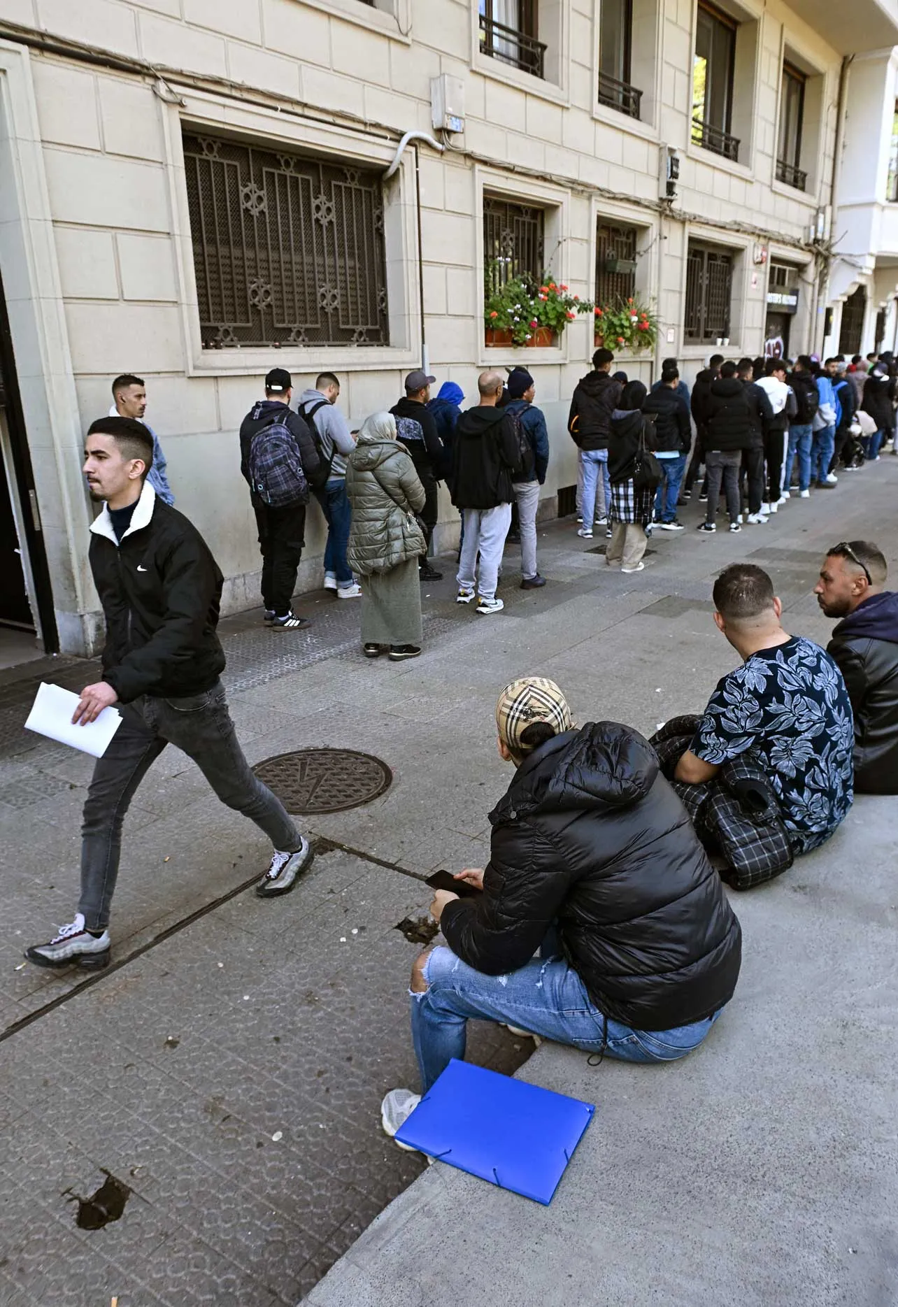 Migrantes haciendo fila en Bilbao para regularizar su situación en España.