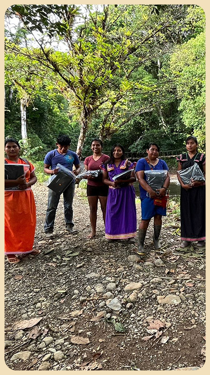 Personas indígenas sostienen computadoras.