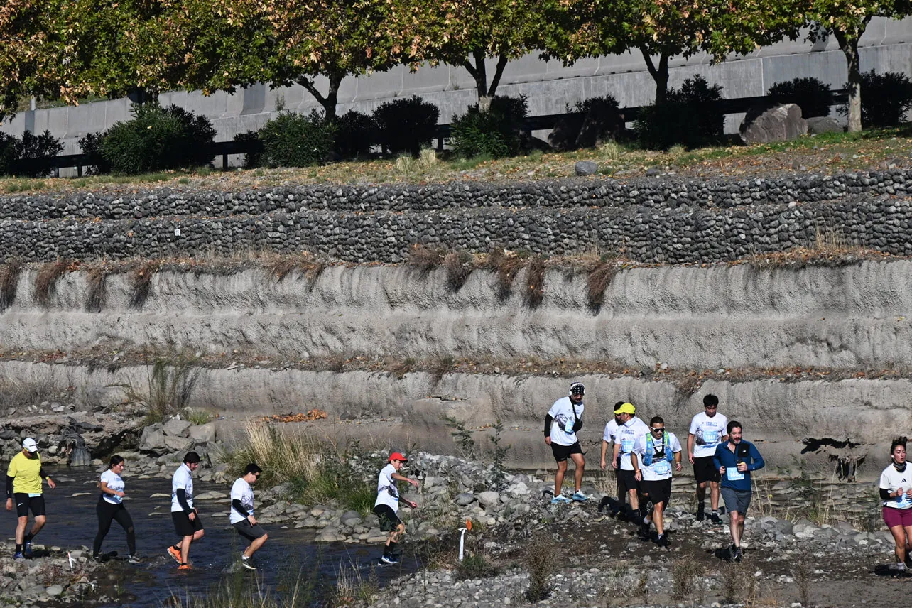 Personas caminando por el río Mapocho.